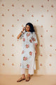 Off-white handwoven khadi cotton tunic with sky blue and pink rose hand block print, paired with mustard bandhani dot printed pants; a handcrafted summer co-ord set made from breathable, natural fabric.