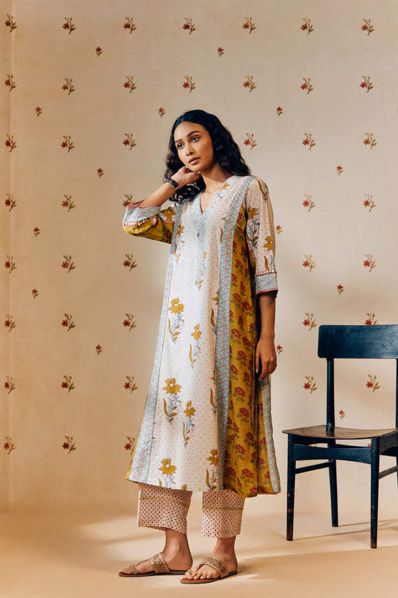 **Alt text:**
Off-white handwoven V-neck cotton mulmul tunic with mustard tulip hand block print, paired with mustard and magenta polka dot printed pants; a breezy, multipanel ethnic co-ord set crafted for comfort and style.