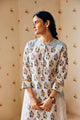 Summer-perfect off-white handwoven khadi cotton tunic featuring blue and mustard flower bunch hand block print, paired with dark blue striped pants; a breathable, handcrafted ethnic co-ord set ideal for warm weather.