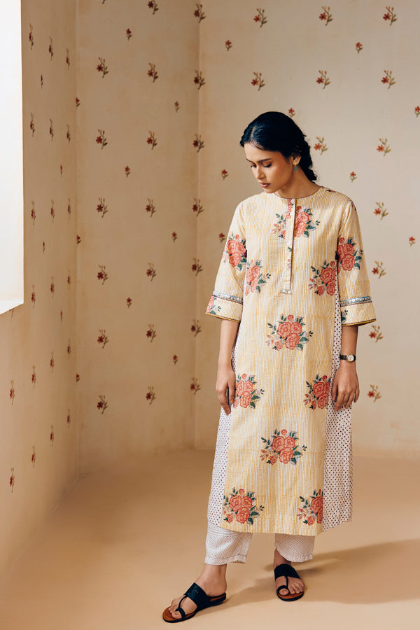 Summer-ready off-white handwoven khadi cotton tunic with mustard stripes and overlapping pink rose hand block print, paired with off-white pants featuring subtle purple microdot print; a handcrafted ethnic co-ord set in breathable cotton.