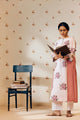 Off-white handwoven khadi cotton tunic with pink rose hand block print, paired with powder pink bandhani dot printed pants; a lightweight, handcrafted co-ord set perfect for summer wear.