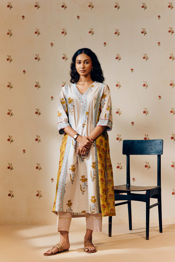 **Alt text:**
Off-white handwoven V-neck cotton mulmul tunic with mustard tulip hand block print, paired with mustard and magenta polka dot printed pants; a breezy, multipanel ethnic co-ord set crafted for comfort and style.