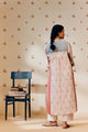 Off-white handwoven khadi cotton tunic with pink rose hand block print, paired with powder pink bandhani dot printed pants; a lightweight, handcrafted co-ord set perfect for summer wear.