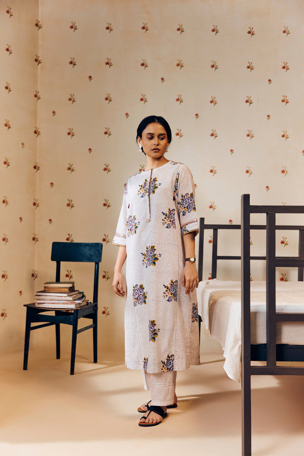 Off-white handwoven khadi cotton tunic featuring a red poppy hand block print, paired with mustard yellow striped pants; an ethnic set blending traditional craftsmanship with contemporary design.




