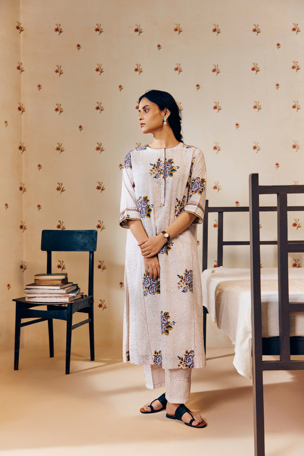 Off-white handwoven khadi cotton tunic featuring a red poppy hand block print, paired with mustard yellow striped pants; an ethnic set blending traditional craftsmanship with contemporary design.




