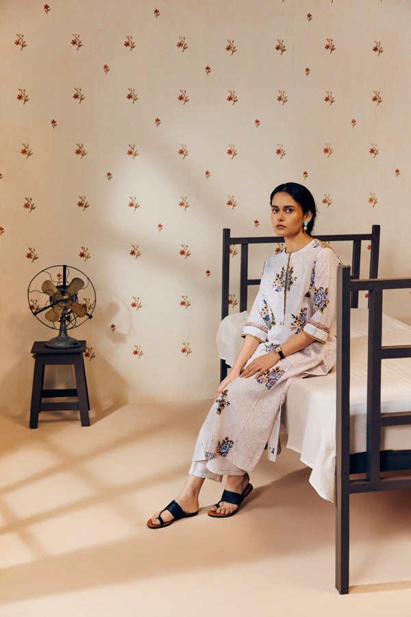 Off-white handwoven khadi cotton tunic featuring a red poppy hand block print, paired with mustard yellow striped pants; an ethnic set blending traditional craftsmanship with contemporary design.




