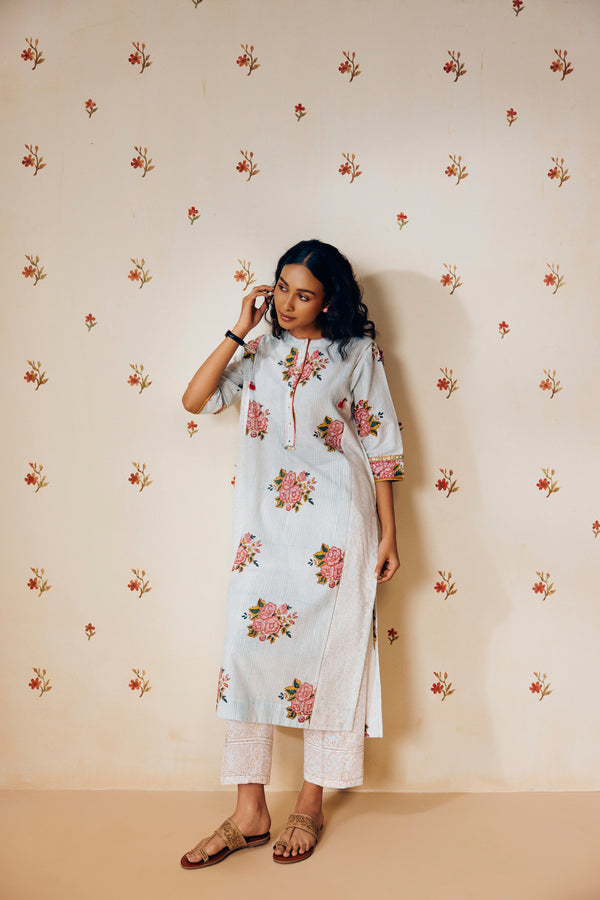Off-white handwoven khadi cotton tunic with sky blue and pink rose hand block print, paired with mustard bandhani dot printed pants; a handcrafted summer co-ord set made from breathable, natural fabric.