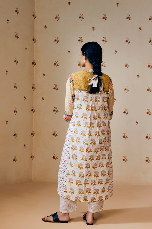 Summer-ready off-white handwoven khadi cotton tunic with mustard stripes and overlapping pink rose hand block print, paired with off-white pants featuring subtle purple microdot print; a handcrafted ethnic co-ord set in breathable cotton.