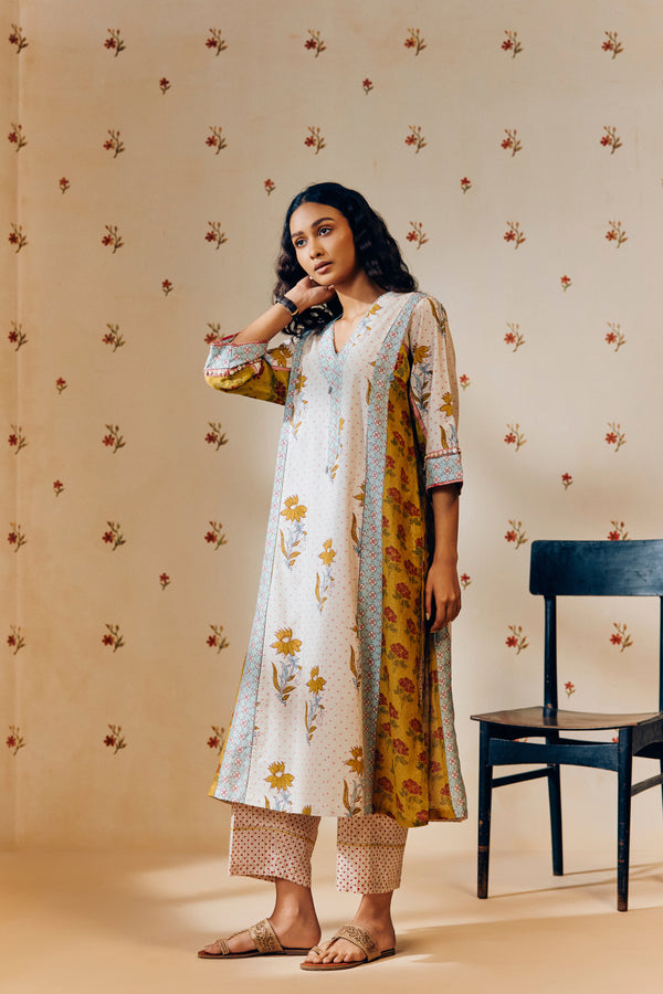 **Alt text:**
Off-white handwoven V-neck cotton mulmul tunic with mustard tulip hand block print, paired with mustard and magenta polka dot printed pants; a breezy, multipanel ethnic co-ord set crafted for comfort and style.
