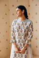 Summer-perfect off-white handwoven khadi cotton tunic featuring blue and mustard flower bunch hand block print, paired with dark blue striped pants; a breathable, handcrafted ethnic co-ord set ideal for warm weather.
