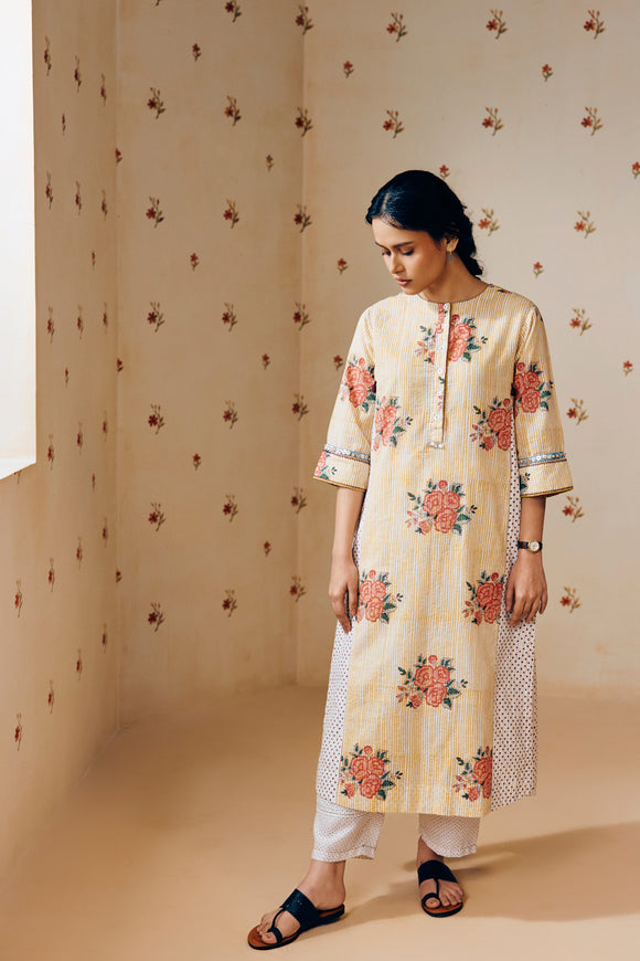 Summer-ready off-white handwoven khadi cotton tunic with mustard stripes and overlapping pink rose hand block print, paired with off-white pants featuring subtle purple microdot print; a handcrafted ethnic co-ord set in breathable cotton.