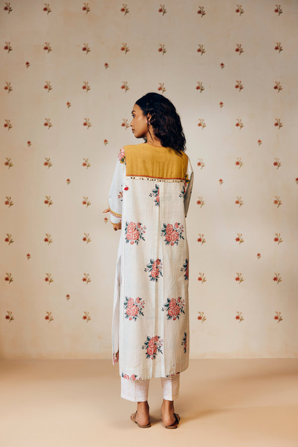 Off-white handwoven khadi cotton tunic with sky blue and pink rose hand block print, paired with mustard bandhani dot printed pants; a handcrafted summer co-ord set made from breathable, natural fabric.