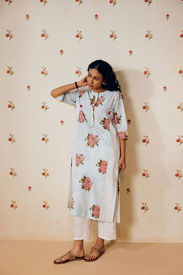 Off-white handwoven khadi cotton tunic with sky blue and pink rose hand block print, paired with mustard bandhani dot printed pants; a handcrafted summer co-ord set made from breathable, natural fabric.
